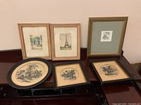 Group photo showing three framed etchings with two rectangular and one oval frame, and three framed embroidered scenic pieces.