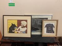 Group shot of three framed paintings displayed on a bench