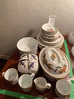Overall layout of plates, bowls, mugs and serving pieces on table