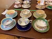 Six assorted teacup and saucer sets arranged on table