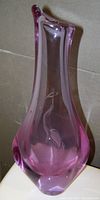 Tall, purple to pink shaded art glass vase with an etched bird design on the lower part, viewed from front.