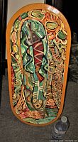 Front view of elongated, rounded rectangular wood panel oil painting with bold textured brush strokes in indigenous impressionist style featuring earth tones and warm ochre border.