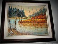 Front view of the signed oil painting showing the landscape with trees, water and reflections, framed with a dark wood frame and white matting.
