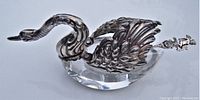 Side view of hinged sterling silver cygnet swan with wings closed over oval crystal bowl