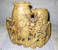 Front angled view of carved dual vase hardstone statue featuring birds on branches and floral motifs with pierced naturalistic base.