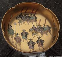 Top-down view showing detailed horses, warriors on horseback, and foot soldiers with banners inside the gold lobed bowl.