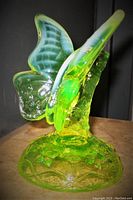 Side view showing butterfly wings and intricate floral branch base