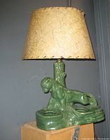 Mid-century style ceramic lamp base shaped as a prowling panther in glossy green with parchment shade.