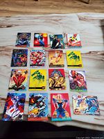 Top down view of 16 Marvel character trading cards laid out on a wooden surface, showing various characters.