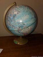 Full view of the 16 inch globe showing Atlantic Ocean and surrounding landmasses, mounted on a gold-colored base and meridian.