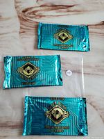 Three sealed packs of Fleer Ultra Reboot trading cards in blue foil packaging, each pack containing 6 cards with computer generated images.