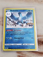 Front side of Articuno Reverse Holo Pokémon card in protective sleeve showing card details and holographic background