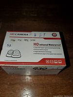 Box showing product name and features including HD Infrared Waterproof camera, DSP digital signal processing, image stabilization, 24-1mm lens, NTSC format.