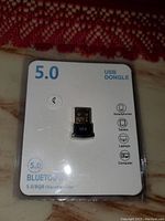Photo of a new USB Bluetooth 5.0 dongle adapter in original packaging.