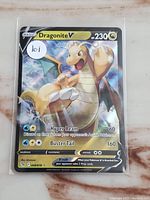 Pokemon Dragonite V holo rare trading card with holographic background, showing Dragonite artwork and card details including HP and attacks.