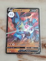 Holo Lucario V card front showing artwork, stats, and card number.