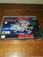 Closed game case showing front cover art with illustration of spaceship and dinosaur, Super Nintendo and Irem branding visible.