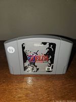 Front view of the gray Nintendo 64 game cartridge showing worn The Legend of Zelda label with Nintendo branding.