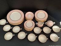 Overview of all pieces including stacked plates, cups, saucers, creamer, and sugar bowl