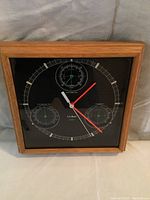Front view of L.L. Bean wall clock showing time and three instrument dials