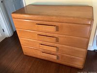 Front view showing overall dresser with four drawers and integrated wood pulls.