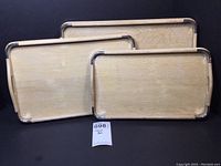 All three blond wood serving trays stacked together, showing the metal corner design and wood grain.