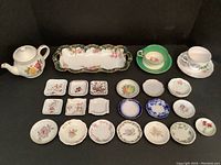 Full lot overview showing Sadler teapot, Limoges celery dish, Aynsley and Royal Vale teacups with saucers, and collection of assorted teabag plates