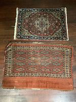 Photo of two small wool rugs laid next to each other on the floor, showing size and pattern differences.