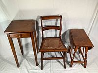Full view of the three-piece furniture set including side table with drawer, caned seat chair, and drop leaf table with sides down.