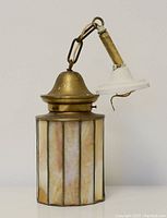 Side view of the stained glass lamp showing vertical glass panels and brass dome.