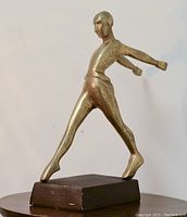 Front side of bronzed metal abstract man statue on rectangular base