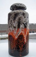 Photo of the 12 inch tall Mid-Century Modern West German Fat Lava pottery vase showing front view with white, orange, and black textured glaze.