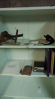 Shelf with several books, the wooden stereoscope, and other items laid out, showing general condition and arrangement.