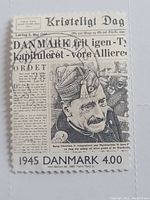 Front view of the vintage Danish stamp showing newspaper text and portrait of King Christian X.