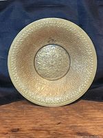 Top view of the antique etched brass bowl showing detailed floral and geometric etchings across the entire surface with a slightly raised center.