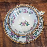 Top view of tea cup sitting in the saucer showing floral and gold rim details