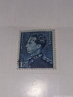 Close-up of first vintage Belgium 1.75 Franc postage stamp, blue with portrait of a man in military uniform, used condition with cancellation marks