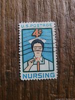 Close-up photo of a single 4 cent U.S. Nursing postage stamp on wooden surface
