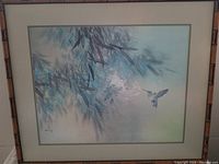 Full view of the framed artwork showing the hummingbird and floral scene in a bamboo-patterned wood frame with double matte.
