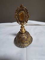 Full view of vintage Matson perfume bottle showing ornate ormolu brass filigree and orange faceted detail on stopper.