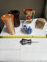 Overview of all six items including vases, clock, and stopper with measuring tape for scale