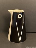 Front view of the black and white penguin pitcher vase with stylized penguin face design