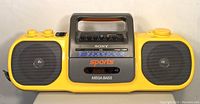 Front view of yellow and gray Sony CFS-914 Sports Mega Bass boombox showing speakers, brand labeling, and radio frequency scale.