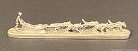 Side view of the full length of the pewter dog sled miniature showing musher and six sled dogs arranged in line pulling the sled.