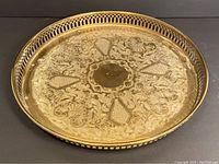 Top view of the vintage brass serving tray showing engraved floral and abstract patterns with a round blank center.