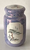 Front view of the jar showing purple crackle glaze and hand painted landscape with pine trees and calligraphy.