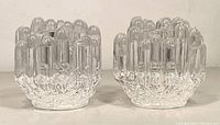 Front view of the pair of clear glass candle holders showing their textured ice-like design