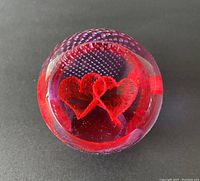 Top view showing two red love heart shapes inside textured clear glass with bubble pattern.