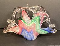 Side view of vintage Murano art glass napkin holder showing clear glass structure with colorful swirled pattern