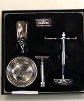 Inside view of the Wahl Barbers Premium Classic Shave Set contents arranged in black molded tray inside box showing brush, bowl, razor handle and razor head.